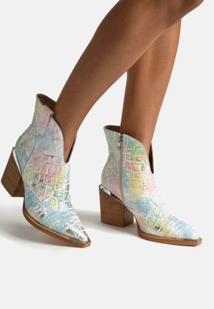 Metallische Knöchelstiefel mit Krokodilmuster, in Pastellfarben, mit spitzem Zehenbereich und Holzblockabsatz. Praktischer Reißverschluss an der Seite für ein einfaches An- und Ausziehen.