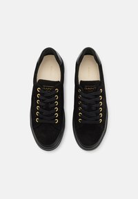 Schwarze Wildledersneaker mit goldenen Ösen und schwarzen Schnürsenkeln. Verfügt über eine glatte schwarze Gummisohle und ein eingeprägtes Markenlogo auf der Zunge.