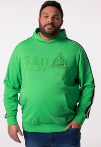 Sudadera verde con un gráfico de velero triangular, bolsillo frontal y franjas laterales negras. Está hecha de una tela cómoda con un corte relajado.