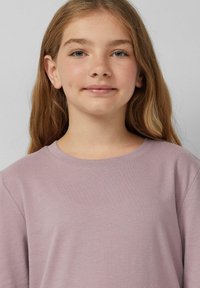 Lichtpaarse t-shirt met korte mouwen en een ronde halslijn, gemaakt van zacht katoen, met een ontspannen pasvorm en minimale stikdetails.