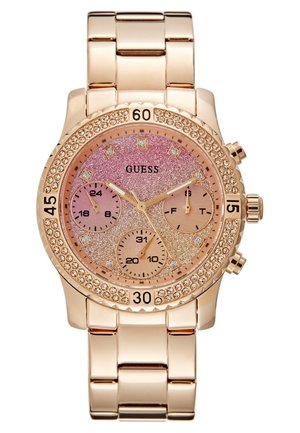 Roseguld metal armbåndsur med glitrende pink urskive, krystalmarkører, tre subskiver og en krystaldækket ramme, mærket GUESS.