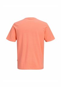 T-shirt corail uni à manches courtes et col rond, montré de dos, avec un ourlet droit et sans logo ni motif visible.