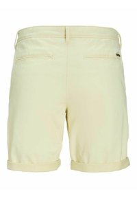 Shorts en coton jaune clair avec un ourlet retroussé, dotés de deux poches arrière et de détails de couture subtils. Se porte à la taille.