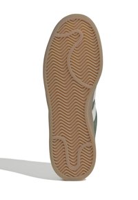 Podešev boty se světle hnědým gumovým vzorkem v podobě šipkového vzoru a zakřivenými drážkami pro lepší přilnavost, na bílém pozadí.