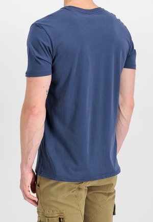 Blå T-shirt med korte ærmer i blød bomuld, med rund halsudskæring og en afslappet pasform. Bagsiden har en enkel, glat tekstur uden mønstre.