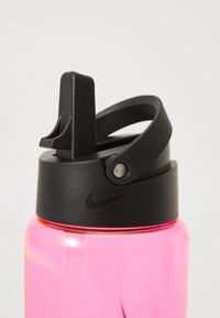 Nike waterfles met een roze, glanzende body. Zwarte dop met een flip-top schenktuit en een handvat voor eenvoudig dragen, voorzien van het Nike-logo.