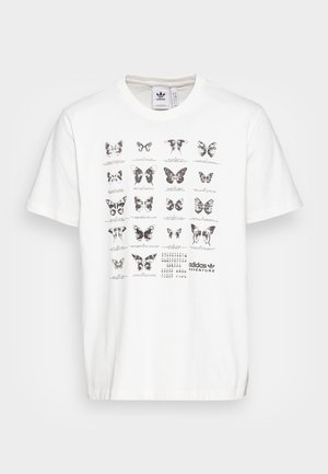 Biała koszulka Adidas z siatką czarno-białych ilustracji motyli i logo Adidas Adventure na środku z przodu.