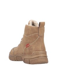 Bottine beige avec une finition ressemblant à du daim, doublure douce, accents rouges, semelle en caoutchouc texturée et couture décorative sur le côté.
