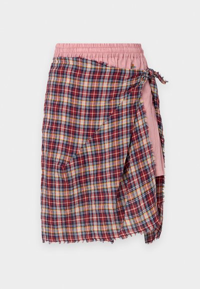 Φούστα περιτυλίγματος με πλέγμα ελέγχου σε κόκκινο, μπλε και κίτρινο χρώμα, με ροζ ελαστική ζώνη και λεπτομέρεια για δέσιμο. Το φθαρμένο τελείωμα προσθέτει υφή.