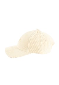 Beige corduroy pet met een gebogen rand, textuurstof, zes-panelen ontwerp en kleine ventilatiegaten aan de zijkanten.