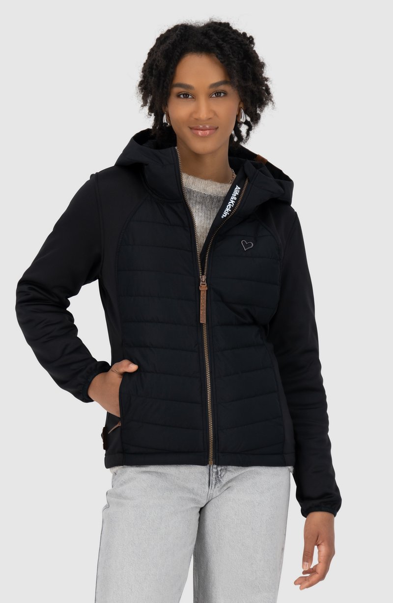 Schwarze Kapuzenjacke mit gestepptem Vorderteil, Reißverschluss und Logodetail. Verfügt über eine weiche Textur und seitliche Taschen. Getragen über einem leichten Pullover.