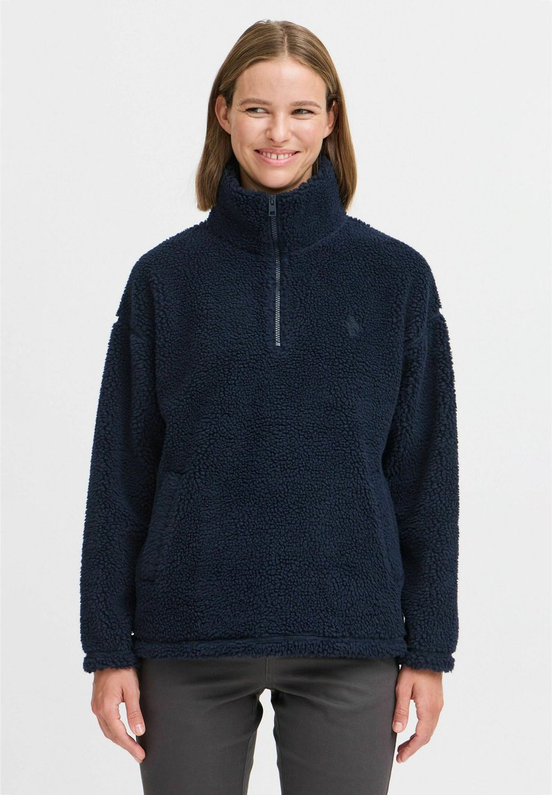 Marineblå fleece-pullover med høy krage, halv-glidelås og teksturert overflate. Har en avslappet passform og synlige sømdetaljer.