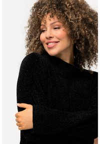 Maglione nero e peloso con collo alto e maniche lunghe, caratterizzato da un design a maglia testurizzata e una vestibilità rilassata, che mette in risalto il comfort.