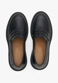 Zwarte leren loafers met een ronde neus, gestikte details en een gladde afwerking. Het interieur heeft een lichthouten inlegzool met logo. Plat rubberen zool.