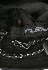 Schwarze Stofftasche mit einem strukturierten Innenraum, verstellbarem schwarz-weißen Zugband und einem silbernen Haken für den Verschluss.