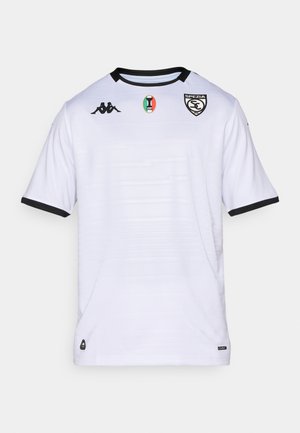 Biała piłkarska koszulka z czarnymi akcentami na dekolcie i rękawach, logo drużyny na piersi oraz teksturowanymi poziomymi liniami.