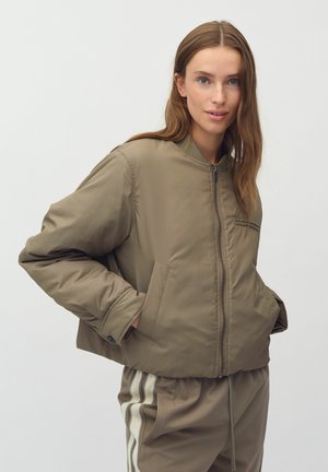 Khaki bomber jacket with a front zipper, standing collar, two side pockets, and a smooth texture. Paired with matching pants featuring stripes.