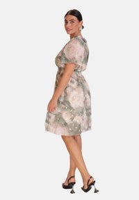 Vestido de estampado floral en tejido suave y liviano, con acentos en verde, rosa y dorado; mangas cortas y cintura elástica para mayor comodidad.