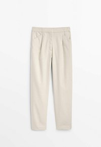 Housut, joissa on pehmeä materiaali, beige väri, joustava vyötärö, kaksi etutaskua ja kapeneva lahje.