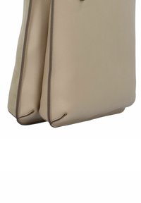 Beige leren handtas met een gestructureerd oppervlak, met contrasterende bruine randen en afgeronde hoeken, weergegeven vanuit een hoek.