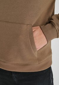 Bruine sweatshirt met een zak aan de voorkant, ribbelmanchetten en -zoom. Zachte stof met een gladde textuur, aansluitend ontwerp en casual stijl.