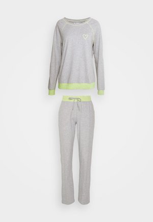 Felpa grigia con maniche lunghe e un piccolo design a forma di cuore, abbinata a pantaloni della tuta grigi con coulisse e vita a strisce.