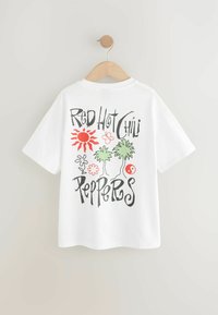 Hvid bomulds t-shirt med et farverigt grafisk design på ryggen, inklusive en rød sol, grønne palmer og teksten "Red Hot Chili Peppers".