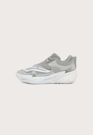 Zapatilla deportiva de caña baja en gris y blanco con parte superior de malla, cierre con cordones y suela gruesa acolchada vista de perfil sobre un fondo liso.