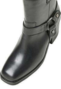 Black leather knee-high boot with a square toe, a buckle strap accent, and a block heel. Smooth texture with subtle stitching detail.
