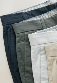 Fire par bukser i marineblå, grå, hvid og beige. Lavet af bomuld med plisseret design og kontrasterende mønstrede taljebånd.