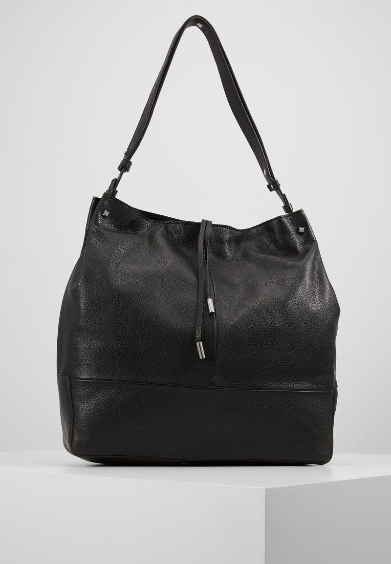 Svart läder tote-väska med en strukturerad yta, justerbar rem, dragsko-stängning och silverfärgade detaljer.