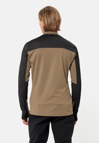 Sportieve top met lange mouwen, voorzien van een bicolor ontwerp met een tan kleurige romp en zwarte schouders, gemaakt van flexibel materiaal met een gladde textuur.