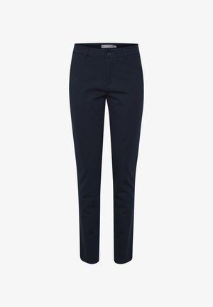 Tumsnējs zils cieši piegulošs bikses ar pogu un rāvējslēdzēja aizdari, jostas cilpām un sānu kabatām, attēlotas baltā fona.