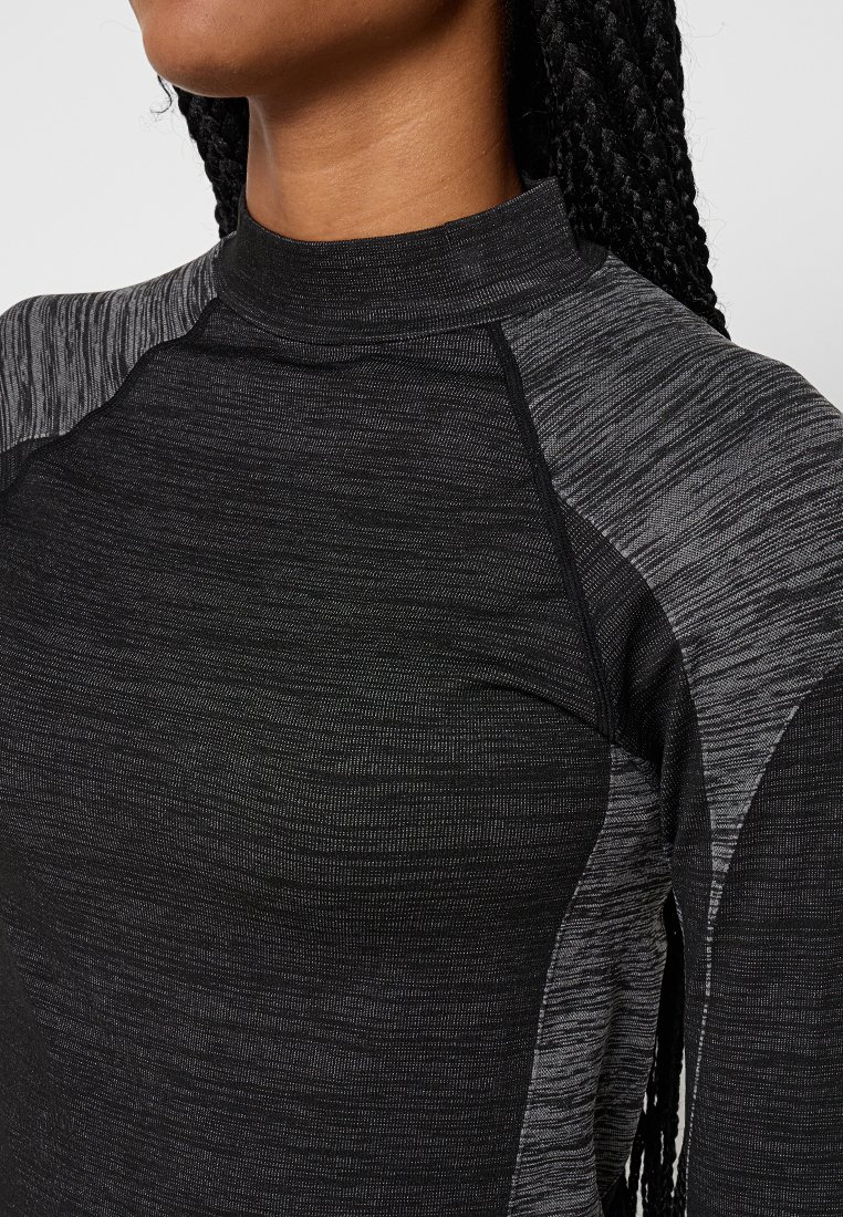 Zwarte sporttop met hoge kraag, textuurstof met subtiele grijze accenten en een aansluitend ontwerp met raglanmouwen.