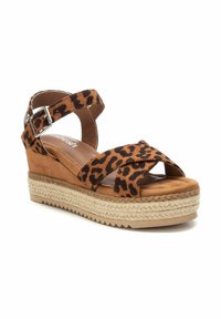 Sandalo con tacco a cuneo in stampa leopardata, con tomaia in suede marrone, cinturino alla caviglia regolabile e soletta in juta intrecciata. Sottopiede imbottito per il comfort.