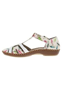 Sandalia blanca con estampado floral multicolor en la zona de los dedos, que presenta un diseño de tiras y una suela marrón texturizada con detalles de costura.