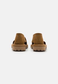 Brune semskede sandaler med åpen bakdesign, tykk gummisåle med teksturert grep og minimal sømdetalj langs kantene.
