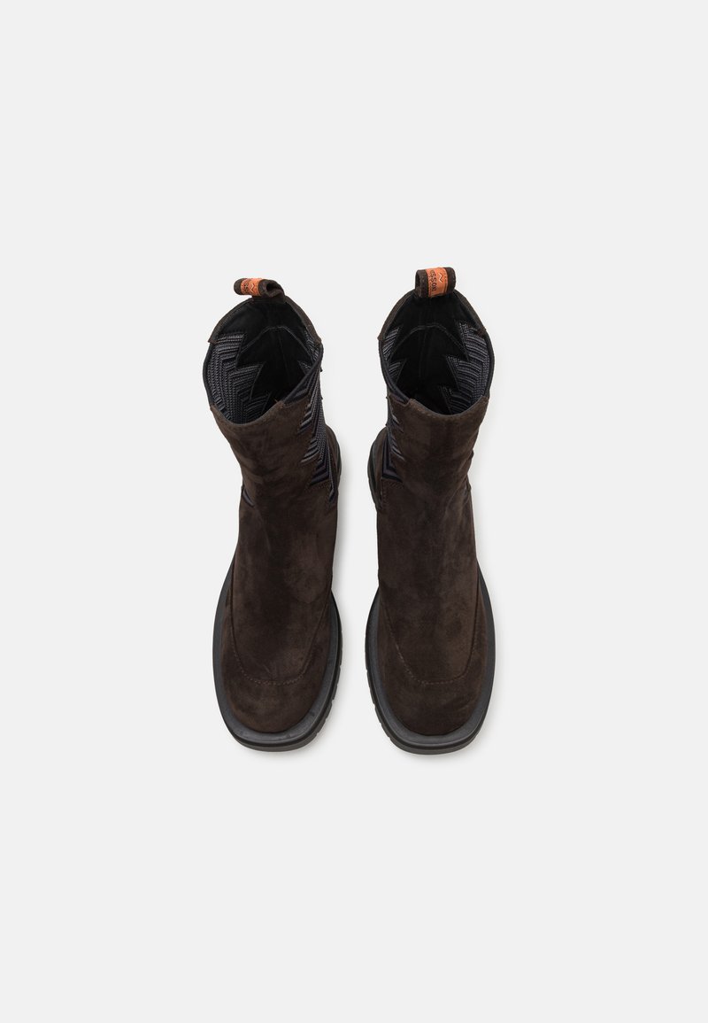 Stivali alla caviglia in suede marrone con rivestimento in tessuto nero testurizzato, punta rotonda e design senza lacci. Dotati di una linguetta per una facile calzata.