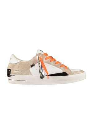 Zapatillas con cordones de parte superior en ante beige y cuero blanco, detalles en negro y cordones naranjas brillantes. Presenta una etiqueta de marca prominente en el lateral.