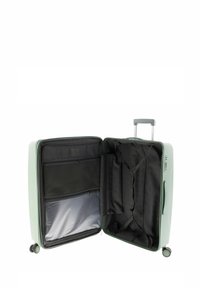 Green hardshell suitcase with double wheels, zip closure, and divided interior featuring black fabric compartments and zippered pockets.