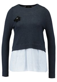 Marineblauer Pullover mit langen Ärmeln, über einem hellblauen und weißen gestreiften Unterteil getragen. Verfügt über eine schwarze Stoffschleifenakzent auf der Brust.
