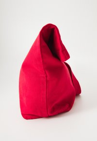 Red fabric handbag with a soft, slouchy shape. Features a folded top and textured surface, creating a casual and functional design.