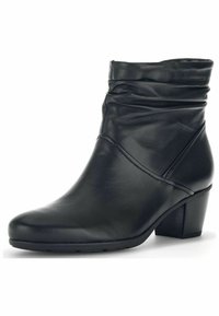Černá kožená kotníková bota se nařaseným svrškem, špičatou špičkou a blokovým podpatkem. Má hladkou texturu a minimální detaily šití.