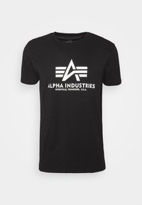 Sort bomulds T-shirt med et hvidt logo med et "A" og tre striber, teksten lyder "ALPHA INDUSTRIES, KNOXVILLE, TENNESSEE, U.S.A."