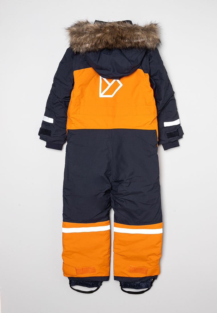 Vinteroverall i marinblått och orange, med en fuskpälsluva, reflexband och en geometrisk logotyp på baksidan.