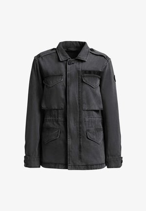 Tummanharmaa sotilaallinen takki, jossa neljä etutaskua läpällä, napillinen kaulus, olkasaumat ja rintataskussa kirjailtu "K.H.U.J."-tekstiili.