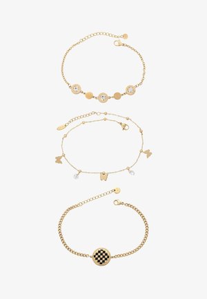 Három arany lánc karkötő: egy kerek, átlátszó kövekkel, egy pillangómedálokkal és apró gyöngyökkel díszített, egy pedig fekete és arany kockás medállal.