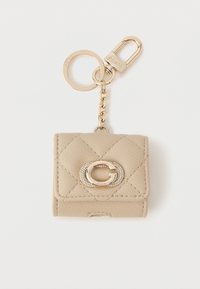 Μπεζ δερμάτινο πορτοφολάκι για κλειδιά με πλακέ υφή, χρυσές λεπτομέρειες, ανάγλυφο λογότυπο και σύνδεση αλυσίδας. Συμπαγής και ορθογώνια σχεδίαση.