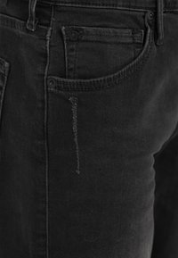 Svarta denimjeans med slim fit, med en framficka, knappstängning och synliga sömdetaljer. Strukturerad tyg med lätt blekning.