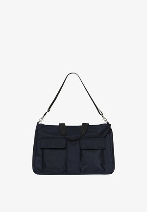Sac à épaule rectangulaire noir avec deux poches avant à rabat et des poignées courtes, présenté suspendu par une longue bandoulière ajustable sur fond blanc.